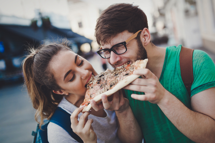 young couple sharing a slice of pizza
